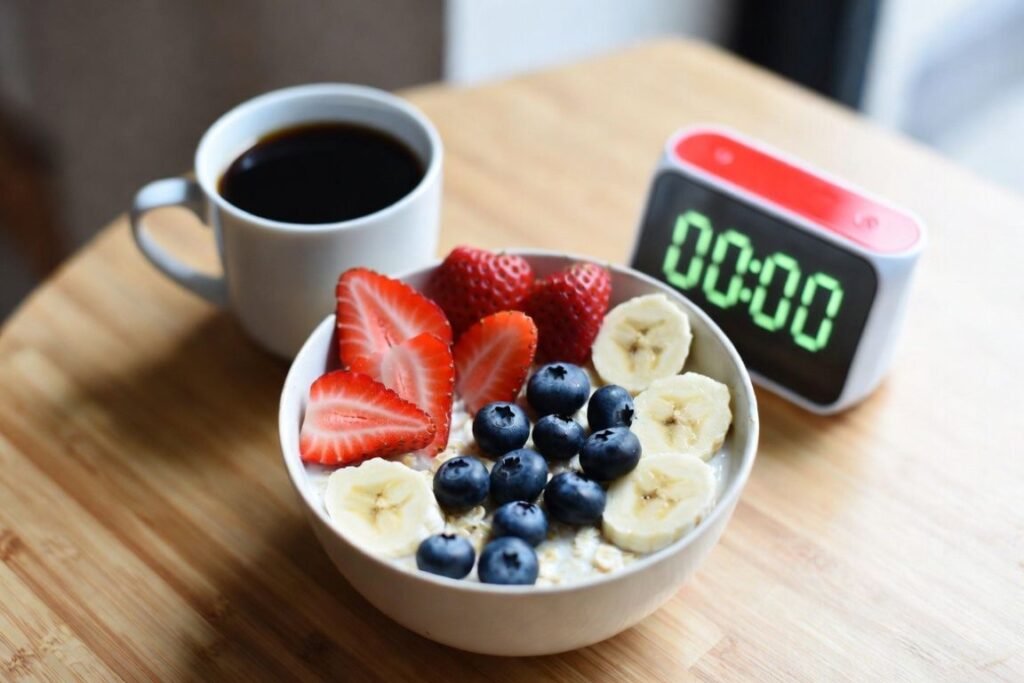 Mesa com a tigela com mirtilo, banana, morango, aveia e café - Como Manter a Motivação na Sua Jornada de Fitness 